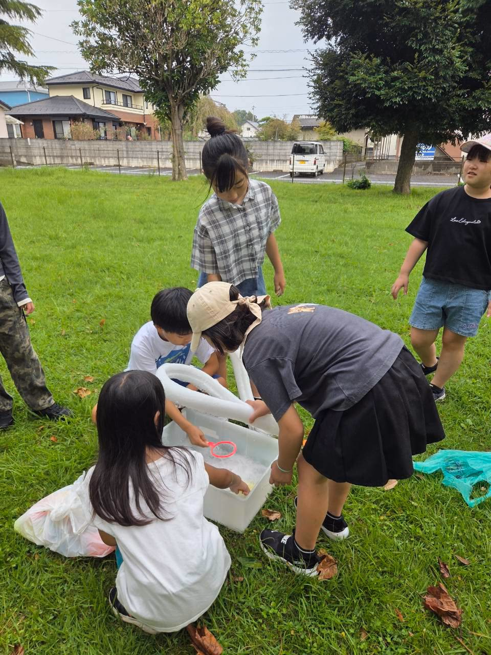Children preparing bubble solution outdoors during Summer School